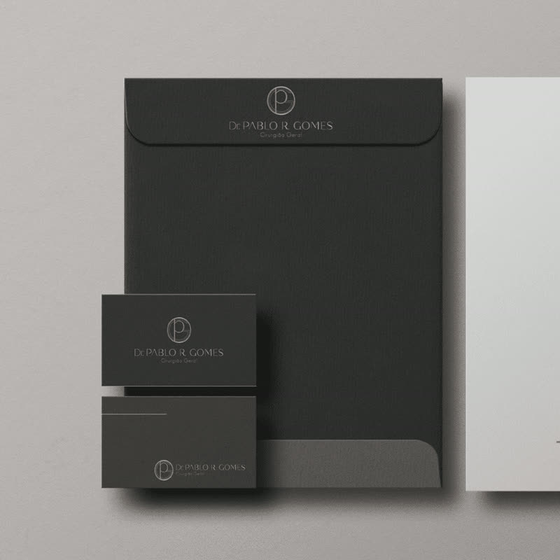 Envelope, cartões e papel timbrado pretos e cinza com a marca do Dr. Pablo R. Gomes, cirurgião geral